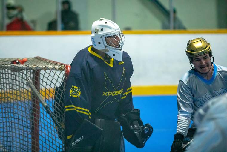 Goaltender and forward sharing a moment at the net